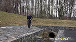 Antonia pees outside next to drainage pipe