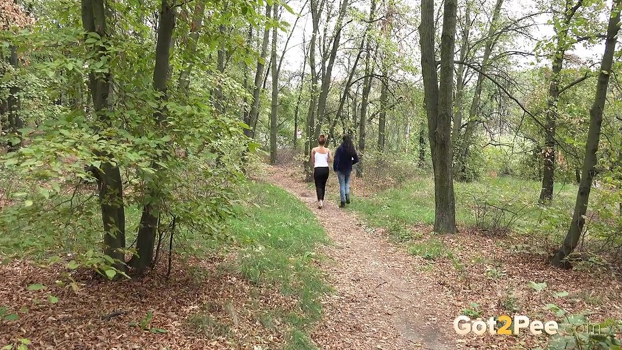 Best friends piss on the ground in the woods