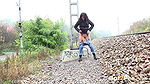 Ali B squats and pees near the train tracks