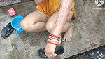 Indian house wife bathing outside with