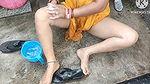 Indian house wife bathing outside with