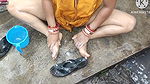 Indian house wife bathing outside with