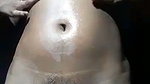 Beautiful girl applying oil on her nude body