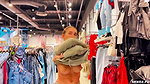 A girl walks around the store with her bare tits out
