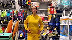A girl walks around the store with her bare tits out