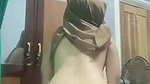 A woman wearing a hijab is using TikTok