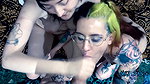 Punk dude with lots of tattoos is having a threesome with two skinny teens
