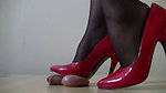 A slender girl in shoes walks on a guy s balls