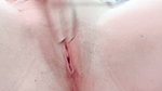in close-up masturbating her young pussy with her fingers until it is wet