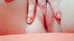in close-up masturbating her young pussy with her fingers until it is wet