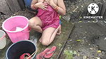 Indian house wife bathing outside