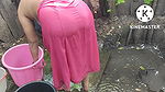 Indian house wife bathing outside