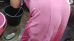 Indian house wife bathing outside with.
