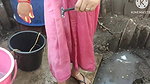 Indian house wife bathing outside with.