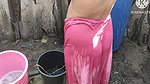 Indian house wife bathing outside with.